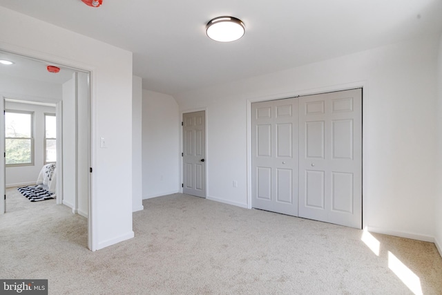 unfurnished bedroom featuring a closet, baseboards, and carpet