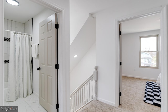 corridor with an upstairs landing, marble finish floor, and baseboards