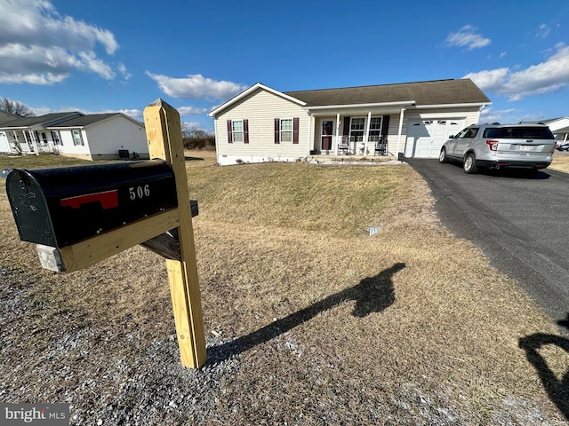 single story home featuring aphalt driveway, covered porch, and a garage