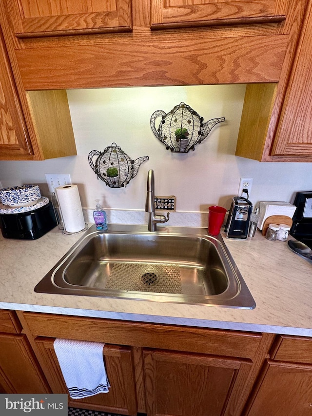 details with a sink, brown cabinets, and light countertops