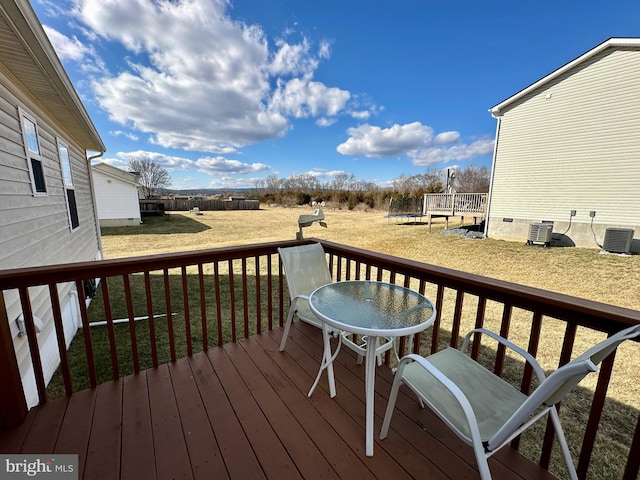 wooden deck with a yard, central AC, and fence