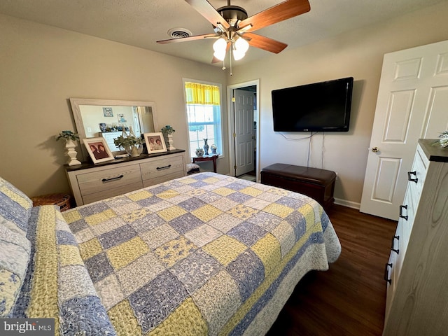 bedroom featuring visible vents, baseboards, a ceiling fan, and dark wood-style flooring