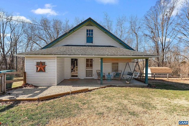 back of property featuring a patio area, a lawn, roof with shingles, and fence