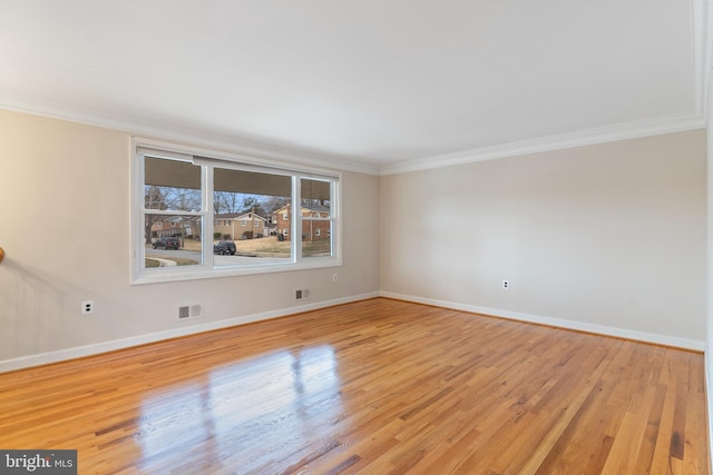 unfurnished room with visible vents, light wood-type flooring, and ornamental molding