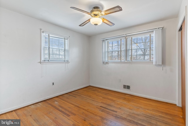 spare room with visible vents, baseboards, a healthy amount of sunlight, and hardwood / wood-style floors