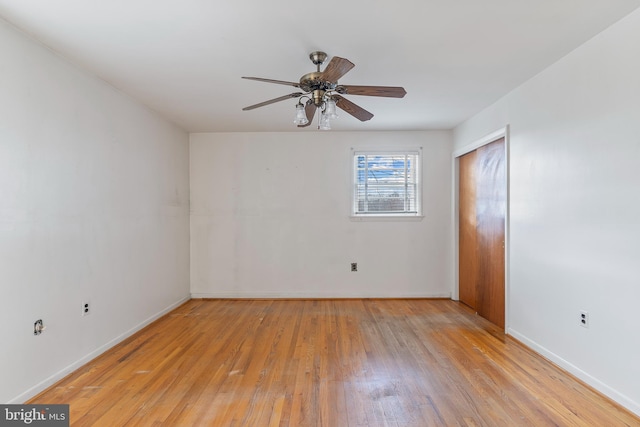 unfurnished bedroom featuring a ceiling fan, wood finished floors, a closet, and baseboards