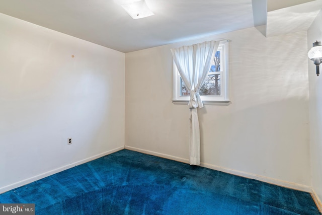 carpeted spare room with baseboards