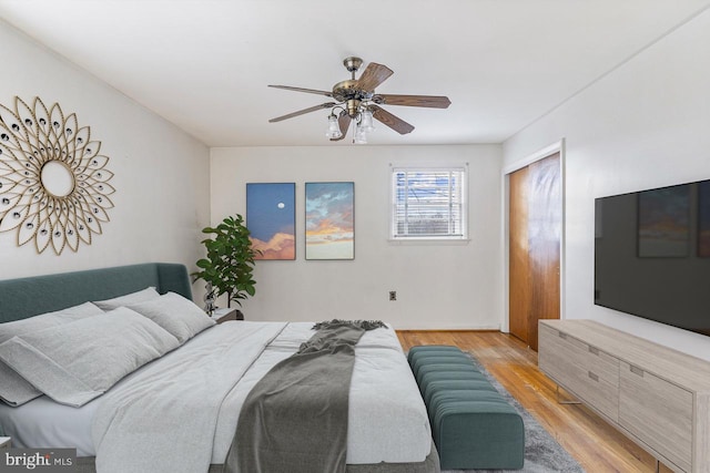 bedroom featuring a ceiling fan, a closet, and light wood finished floors