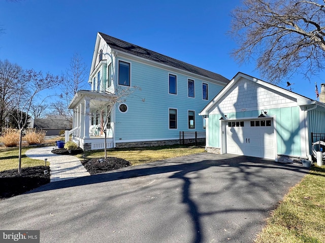 view of property exterior featuring a porch, an attached garage, board and batten siding, and driveway