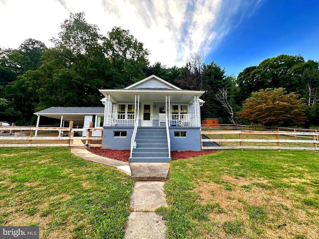 view of front of home with stairway, covered porch, a front lawn, and fence