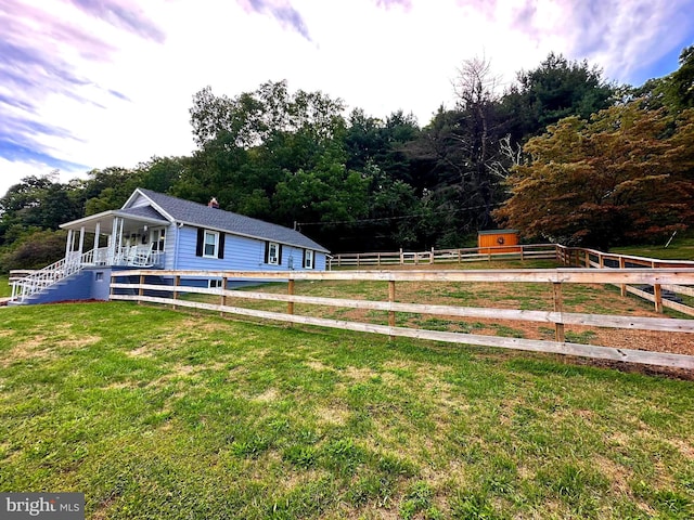 view of front of home featuring an outbuilding, a front lawn, and fence