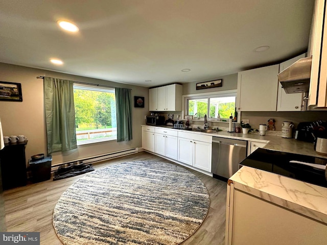 kitchen with under cabinet range hood, light wood-style flooring, appliances with stainless steel finishes, and a sink