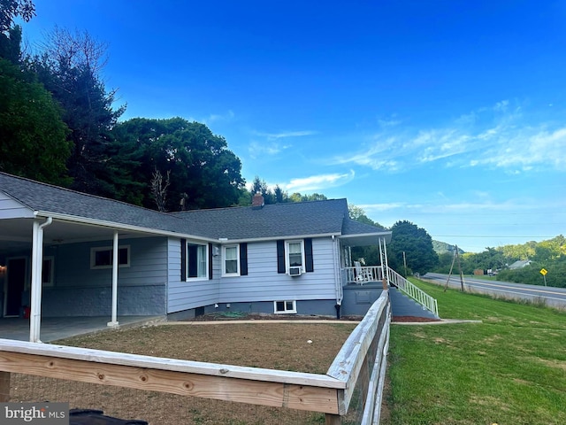 view of front of house with a chimney, a front yard, and a shingled roof