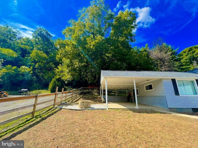 view of yard featuring a carport and fence