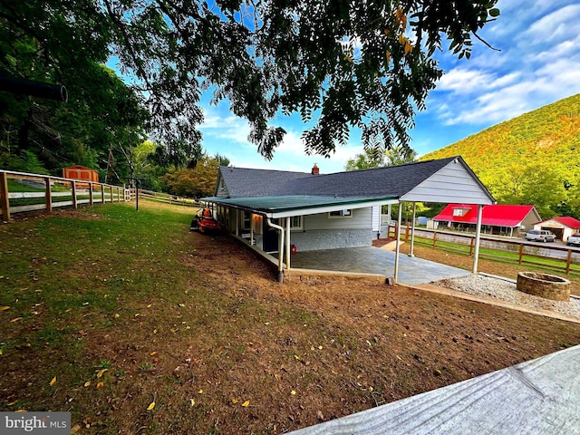 view of yard featuring a patio, fence, and an outdoor fire pit