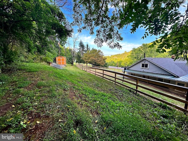 view of yard with a storage unit, an outdoor structure, and fence