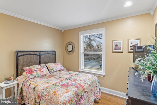 bedroom featuring recessed lighting, wood finished floors, baseboards, and ornamental molding