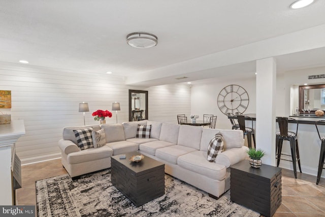 living area featuring recessed lighting, baseboards, and wood walls