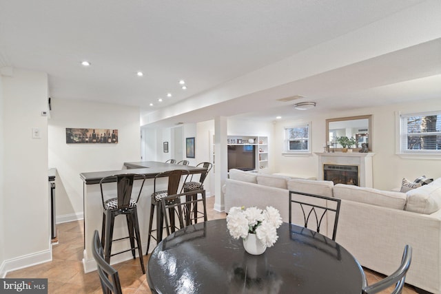 dining space with recessed lighting, a fireplace, baseboards, and light tile patterned floors