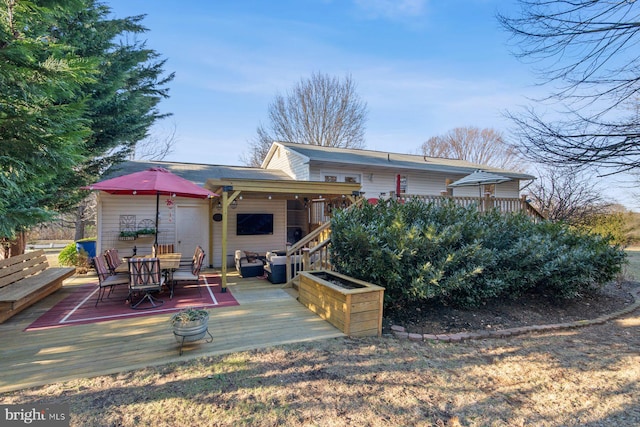 back of house with outdoor dining space and a deck