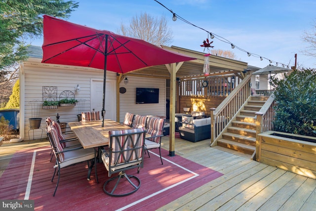 wooden deck featuring stairway and outdoor dining space