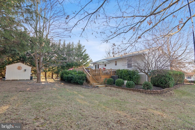 view of yard with a wooden deck, an outbuilding, a storage shed, and stairs