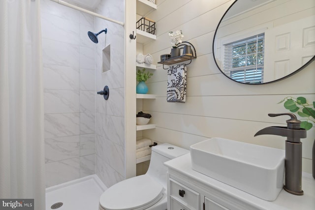 bathroom with a stall shower, toilet, and vanity