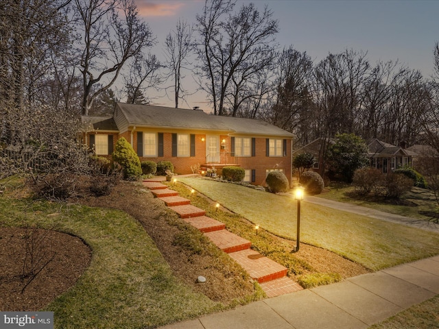 ranch-style home with brick siding and a front yard