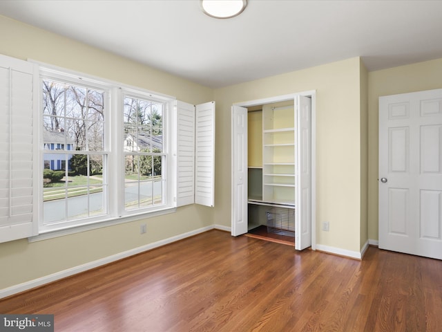 unfurnished bedroom featuring a closet, baseboards, and wood finished floors