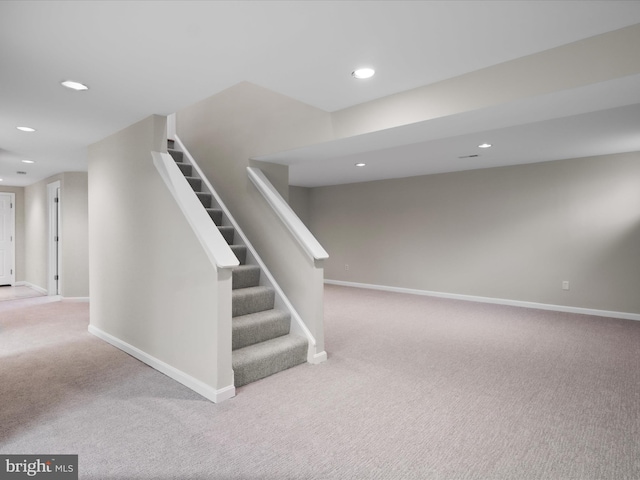 basement with stairway, recessed lighting, baseboards, and carpet