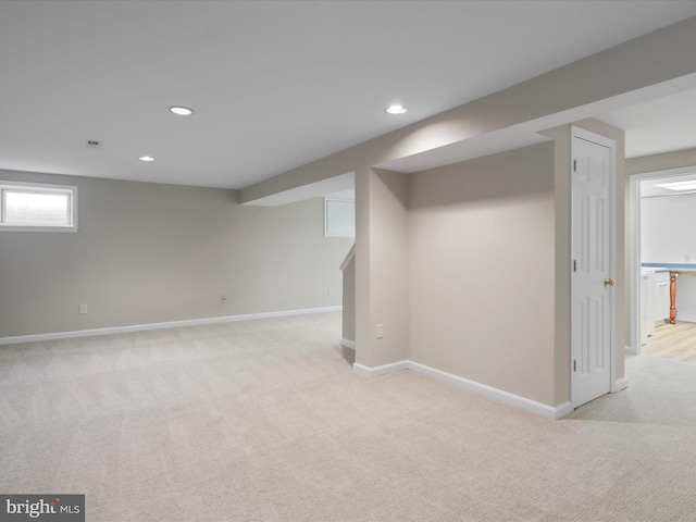 basement with recessed lighting, light colored carpet, and baseboards