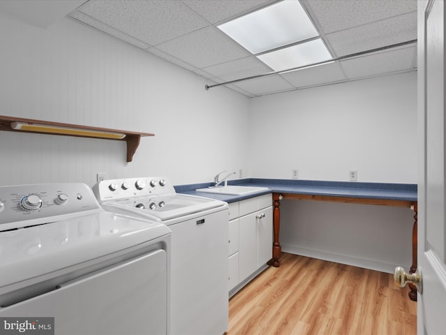 laundry area with a sink, cabinet space, light wood-style floors, and independent washer and dryer