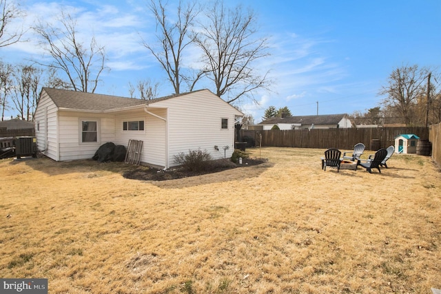 exterior space featuring cooling unit, a fenced backyard, and an outdoor fire pit