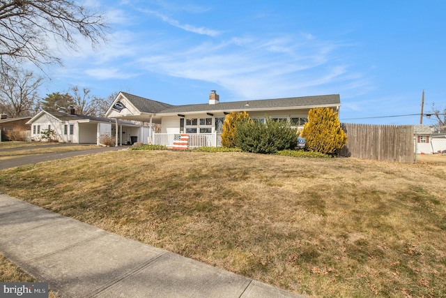 view of front of home with a front yard, a porch, fence, and a chimney