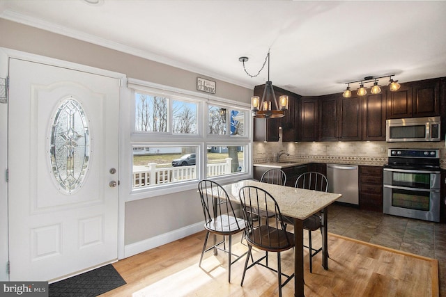 dining area with ornamental molding, baseboards, and wood finished floors