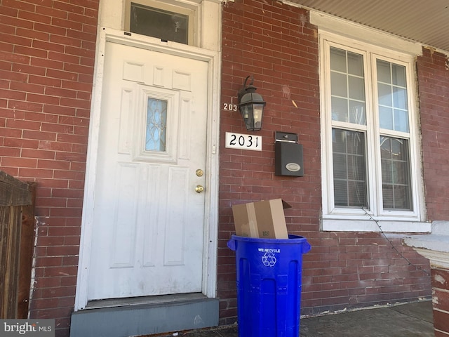 doorway to property with brick siding