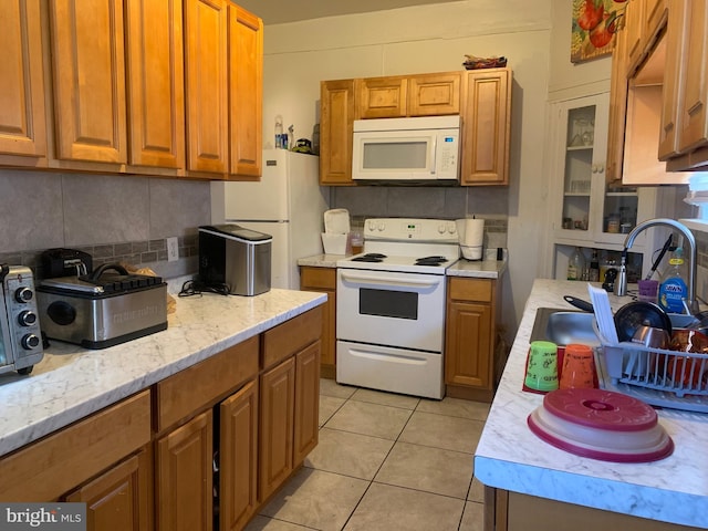 kitchen featuring white appliances, brown cabinetry, and tasteful backsplash