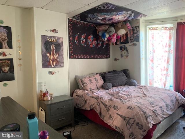 carpeted bedroom with a drop ceiling