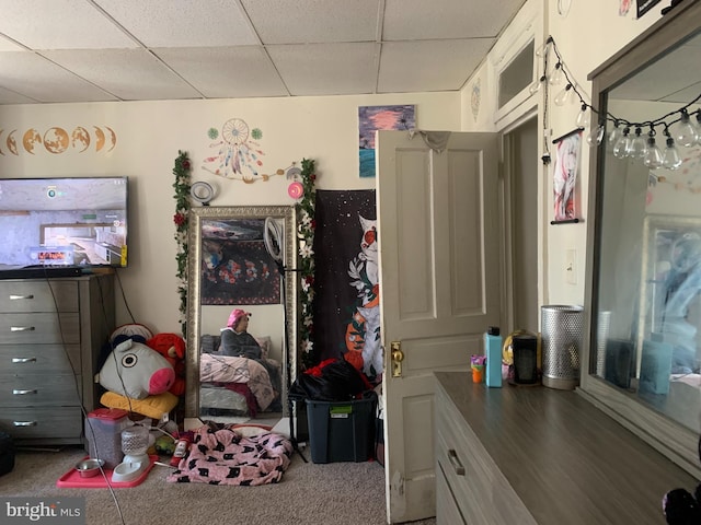 carpeted bedroom featuring a drop ceiling