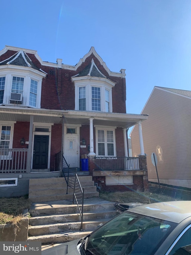 view of front facade featuring brick siding and covered porch