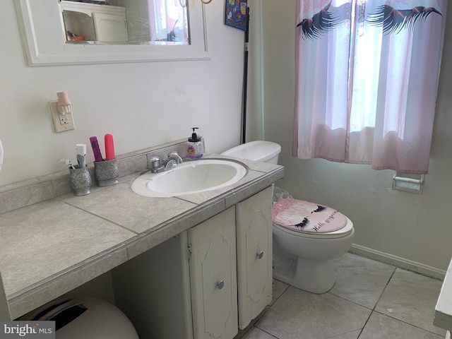 bathroom with vanity, toilet, baseboards, and tile patterned flooring