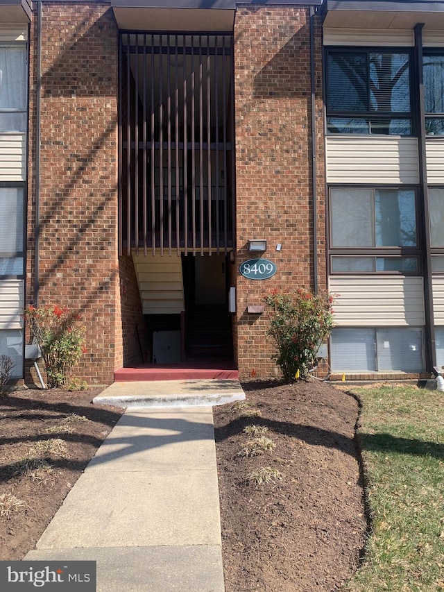 view of exterior entry with brick siding