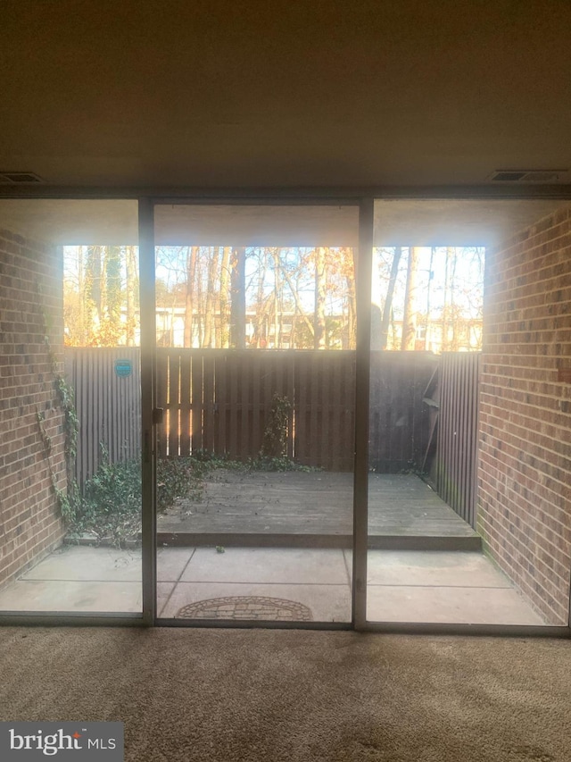 entryway featuring carpet flooring and brick wall