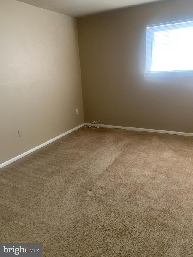 carpeted spare room with baseboards