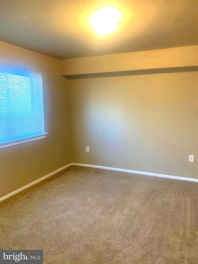 carpeted spare room with baseboards