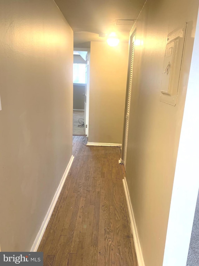 hallway featuring baseboards and wood finished floors