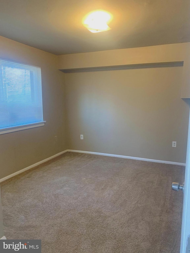 carpeted empty room with baseboards