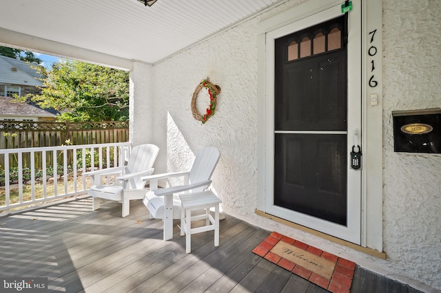 doorway to property with stucco siding and fence