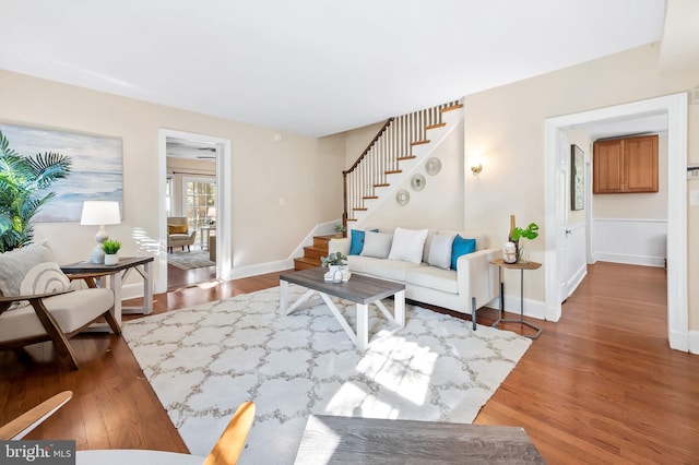 living area featuring stairway, wood finished floors, and baseboards