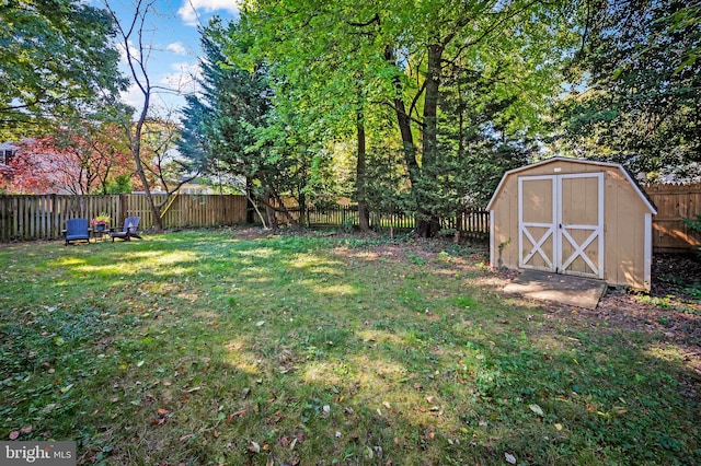 view of yard with an outbuilding, a shed, and a fenced backyard